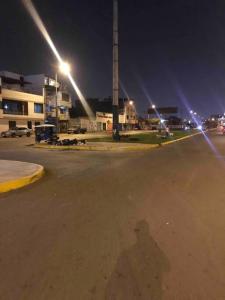 Warm House Near the Airport Callao في ليما: ظل شخص في موقف للسيارات في الليل