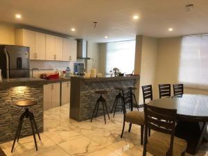 a kitchen with a table and some chairs and a counter at Warm House Near the Airport Callao in Lima