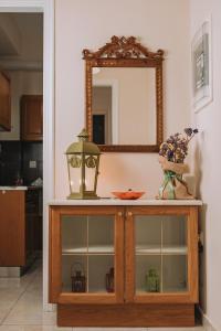 a mirror on top of a cabinet in a kitchen at Nostos apartment, with a spacious backyard in Artemida