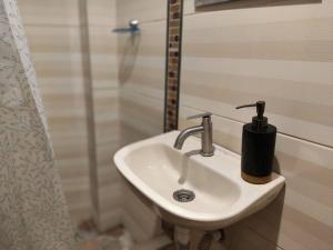 - Baño con lavabo blanco y ducha en Warm House Near the Airport Callao en Lima