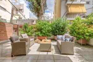 a patio with wicker chairs and a coffee table at Nostos apartment, with a spacious backyard in Artemida
