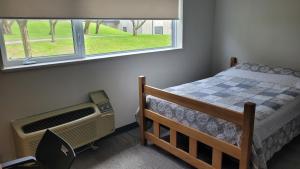 1 dormitorio con cama y ventana en Residence & Conference Centre - Brockville, en Brockville