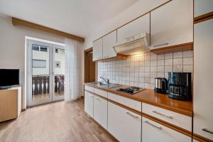 a kitchen with white cabinets and a counter top at Haus Pfattner in Lana