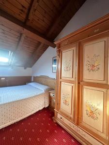 FozaにあるHotel Alpi - Fozaのベッドルーム1室(ベッド2台、木製キャビネット付)