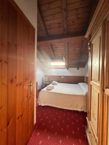 FozaにあるHotel Alpi - Fozaの木製の天井の客室で、ベッドルーム1室(ベッド1台付)