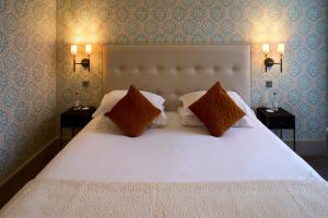 a bedroom with a large white bed with two night stands at The Petersham in Richmond upon Thames