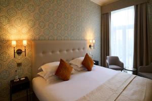 a bedroom with a large white bed and a window at The Petersham in Richmond upon Thames