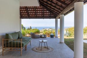 d'une terrasse avec un canapé, des chaises et une table. dans l'établissement Villa Serenità - with private pool and ocean view, à Ricadi