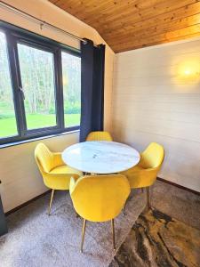 ein Esszimmer mit gelben Stühlen und einem Tisch in der Unterkunft Magpie 3 HuntersMoon-Longleat-Warminster-Bath in Warminster