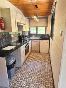 una cucina con armadietti bianchi e pavimento piastrellato di Magpie 3 HuntersMoon-Longleat-Warminster-Bath a Warminster