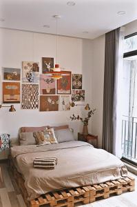 1 cama en un dormitorio con cuadros en la pared en Langmandi Experience 9NT, en Hanói