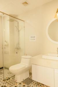 Baño blanco con aseo y lavamanos en Langmandi Experience 9NT, en Hanói