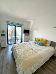 a large bed in a bedroom with a large window at GoldBeach House in Pataias