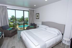 a bedroom with a bed and a balcony with a pool at Pirates Bay A308 in Fort Walton Beach