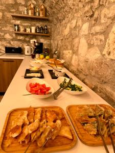 a kitchen counter with a table with food on it at Helin's Hostel by Backpackers in Berat