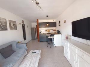 a living room with a couch and a flat screen tv at Apartamento LIFE Complex Amaya Fuerteventura in Costa de Antigua