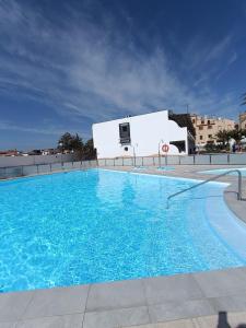 a large blue swimming pool in front of a building at Apartamento LIFE Complex Amaya Fuerteventura in Costa de Antigua