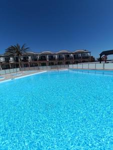 a large pool of blue water in front of a building at Apartamento LIFE Complex Amaya Fuerteventura in Costa de Antigua