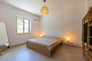 - une chambre avec un lit, une fenêtre et 2 lampes dans l'établissement Villa Serenità - with private pool and ocean view, à Ricadi