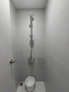 a bathroom with a shower with a toilet in it at Twin Hearts Residences Unit 215 in Roxas City