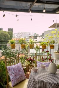 una mesa y sillas en un balcón con plantas en Langmandi Experience 9NT, en Hanói