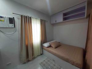 a small room with a bed and a window at Twin Hearts Residences Unit 215 in Roxas City
