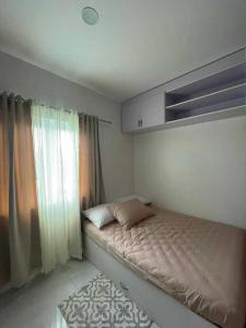 um pequeno quarto com uma cama e uma janela em Twin Hearts Residences Unit 215 em Roxas