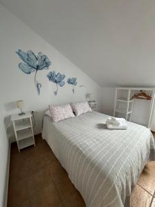1 dormitorio con 1 cama con flores azules en la pared en SON DE MAR en Bolonia