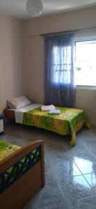 two beds in a room with a window at Mihalis Vrion Apartment in Vrion