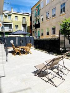 een patio met stoelen, een tafel en een parasol bij LUME, Family Apartment in Murano