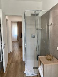 een badkamer met een douche en een glazen deur bij LUME, Family Apartment in Murano