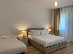 een slaapkamer met 2 bedden en 2 lampen op tafels bij LUME, Family Apartment in Murano