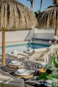 una mesa con copas de vino y sombrillas junto a una piscina en Villa La Sala Puerto Banus, en Marbella