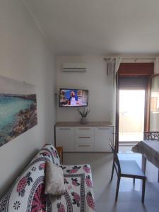 ein Schlafzimmer mit einem Bett und einem TV an der Wand in der Unterkunft CASA CIELO in Favignana