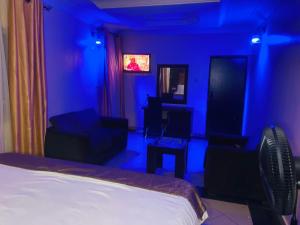 a bedroom with a blue room with a bed and chairs at Havilah Suites Ltd, Nnewi in Nnewi