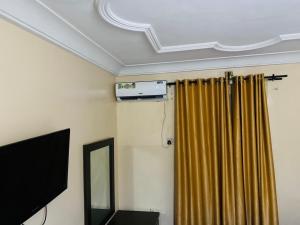 a room with a ceiling with a curtain and a mirror at Havilah Suites Ltd, Nnewi in Nnewi