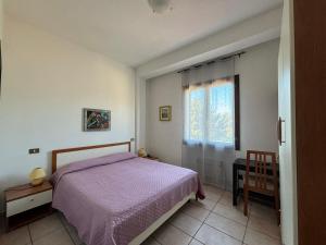 a bedroom with a purple bed and a window at Albergo Dolcedo in Imperia
