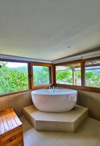 bañera grande en una habitación con ventanas en Sofia's Lake Resort en Cavinti