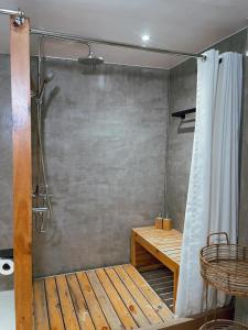 a bathroom with a shower with a bench and a shower curtain at Sofia's Lake Resort in Cavinti