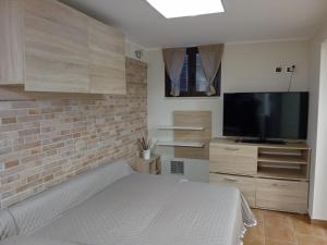 a bedroom with a bed and a flat screen tv at Casa Alessia in Catania