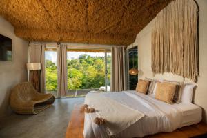 a bedroom with a large bed and a large window at Casa Lamia in Manuel Antonio