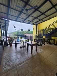 a room with tables and benches and a balcony at B Aparts Hotel in Coxen Hole
