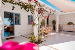 a white patio with a table and flowers at Ecovilla Haleakala con Piscina y Sauna privadas in Villaverde