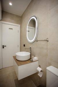 a bathroom with a sink and a mirror at Oro Inn Hotel in Shkodër