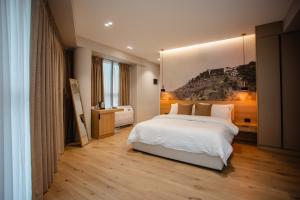 Un dormitorio con una cama blanca y una pintura en la pared en Oro Inn Hotel, en Shkodër 37 fotos más