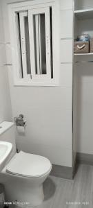 a white bathroom with a toilet and a mirror at Apartamento en Ciudad Jardín a 8 min Casco Historico in Córdoba