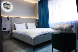 sypialnia z łóżkiem i dużym oknem w obiekcie Riverside Burabay Hotel w mieście Borowoje