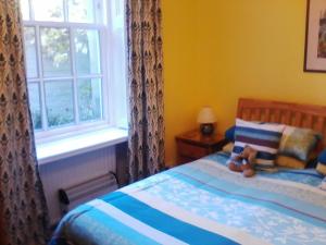 a bedroom with a bed with a teddy bear on it at The Spindle Guest Rooms in St Andrews