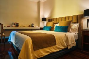 a bedroom with a large bed with blue pillows at Miravida Soho Hotel & Wine Bar in Buenos Aires