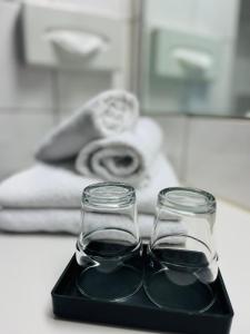 dos vasos de vidrio sentados en una bandeja negra en Good Morning + Bad Oldesloe en Bad Oldesloe